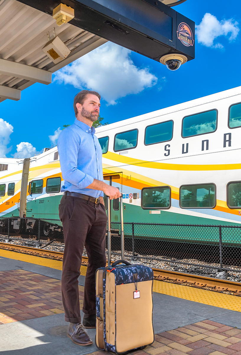Man with suitcase on platform waiting for SunRail Train.