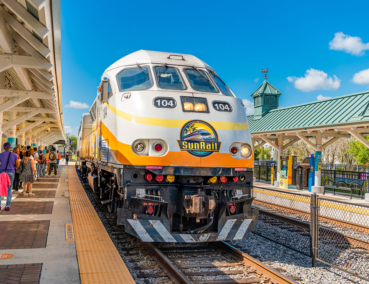 SunRail Train at Kissimmee Station with riders waiting to board.