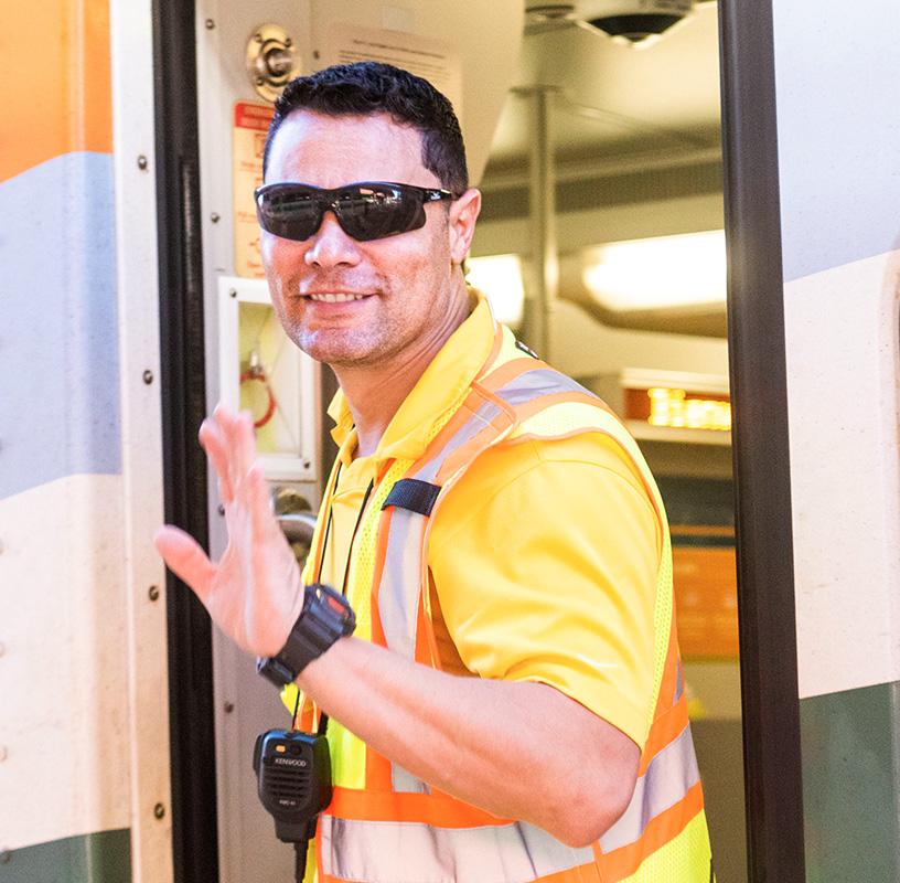 SunRail Conductor waving from train entrance.