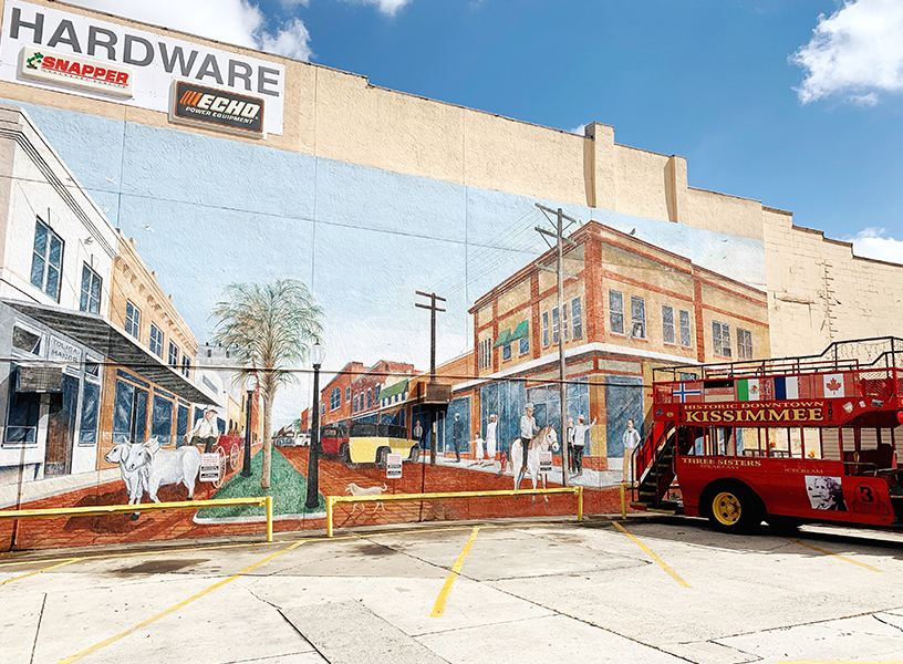 Hardware store with mural and double decker bus in parking spot