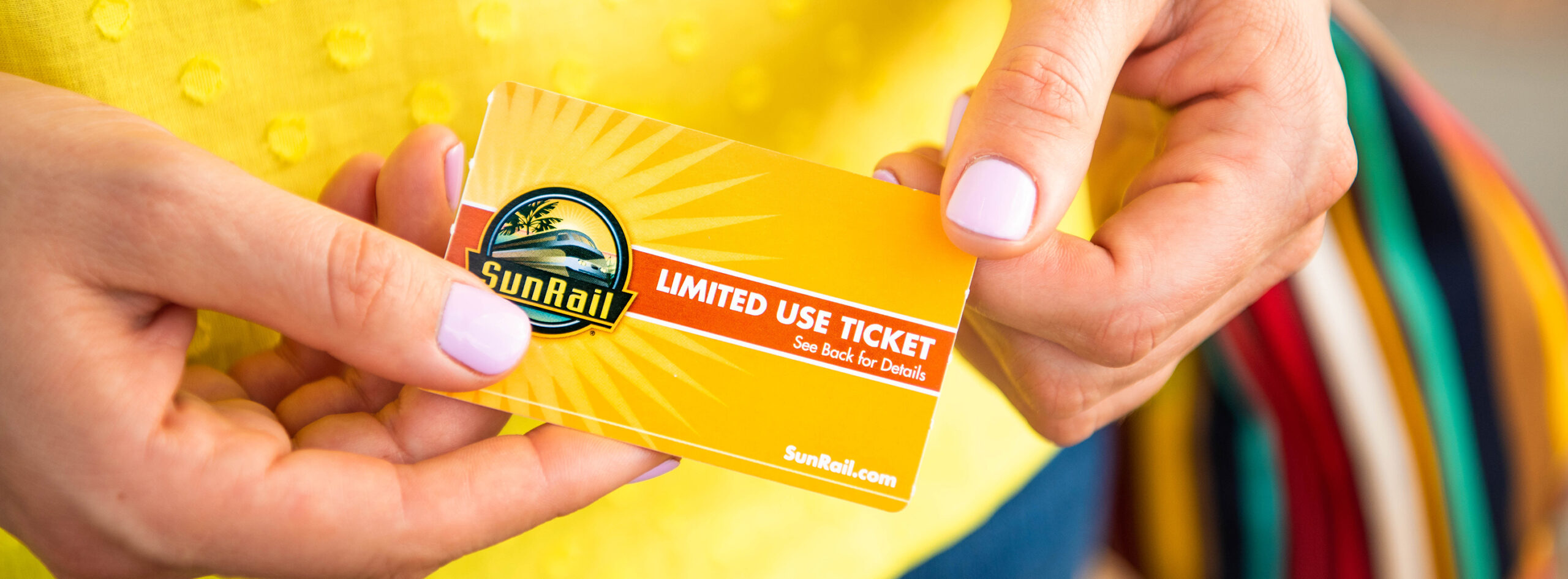 Masthead image - Woman holding a SunRail Ticket.