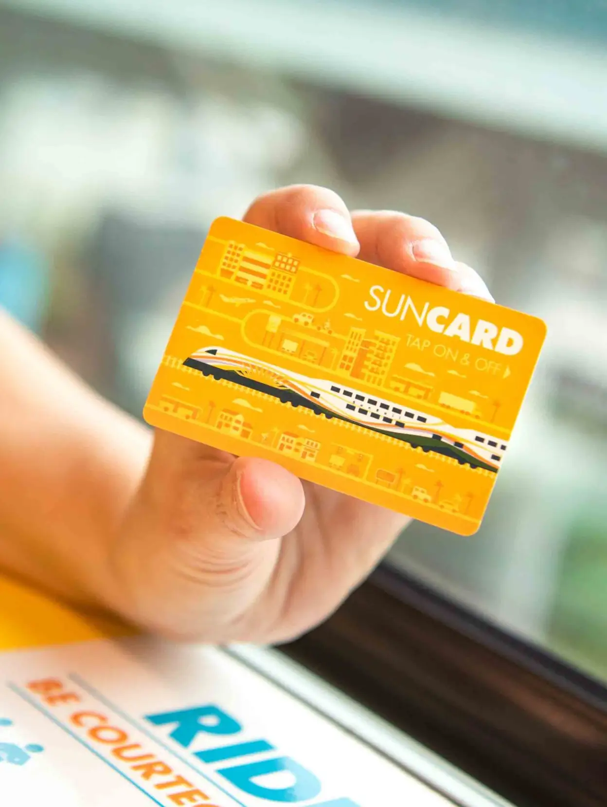 SunRail Rider holding a SunCard on table.