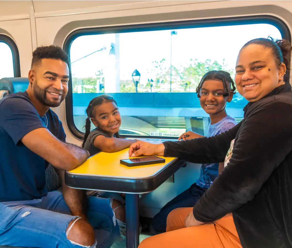 A family of SunRail passengers sit on SunRail, waiting for the train to depart.