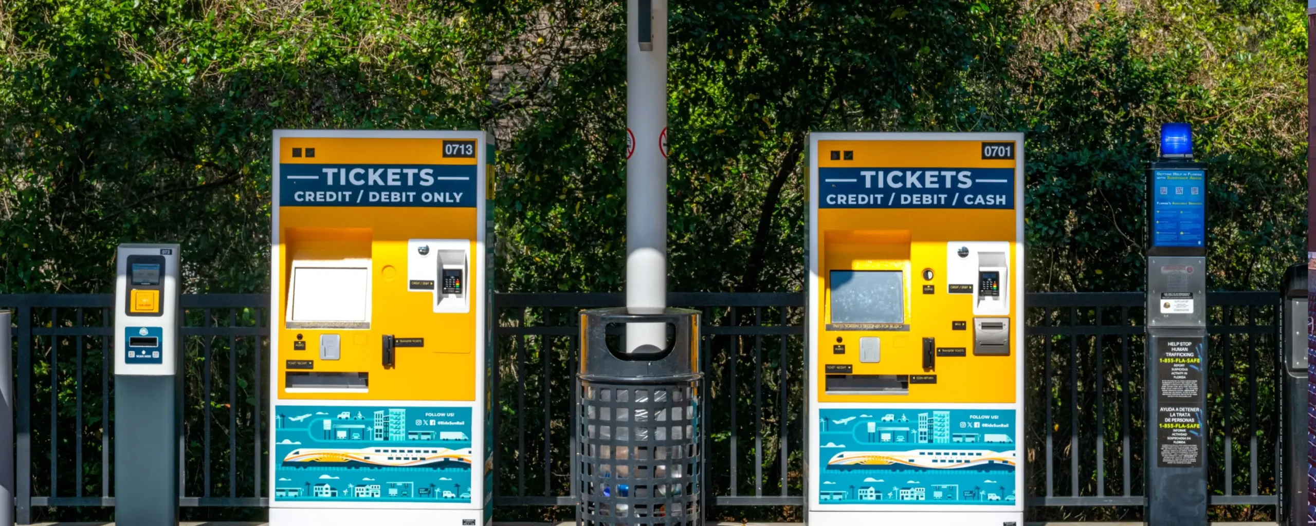 A ticket validator unit, two ticket vending machines, and an emergency call box at a SunRail station.