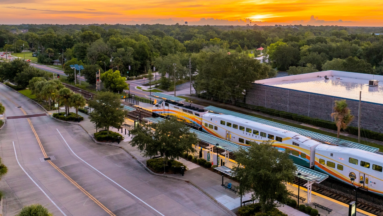 Aerial photo of a SunRail train at the Altamonte Springs SunRail station with the sunrise in the background.