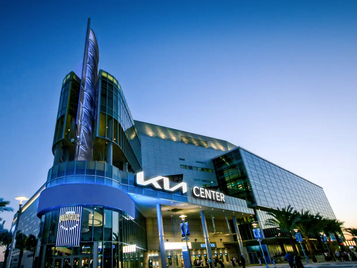 Kia Center exterior in Orlando with illuminated signage at dusk, main entrance visible
