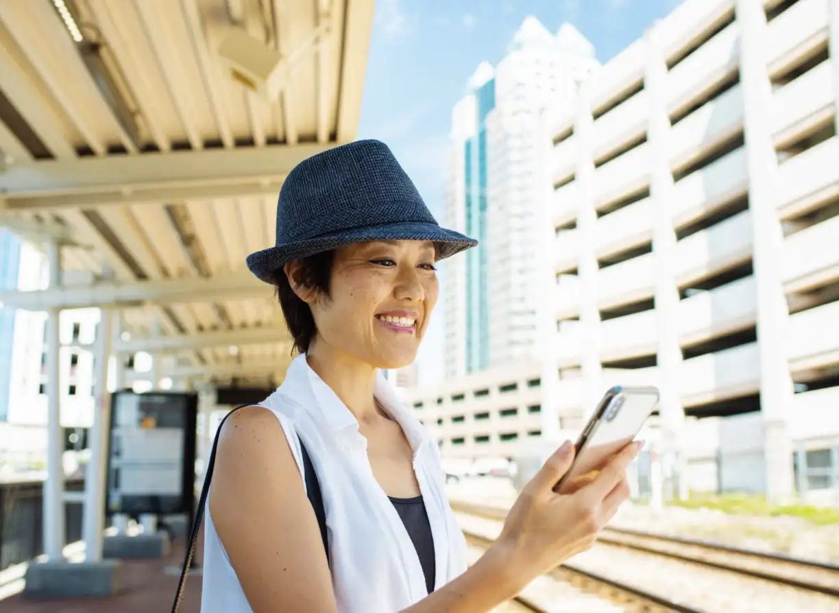 SunRail passenger at the Church Street Station platform looking at phone.